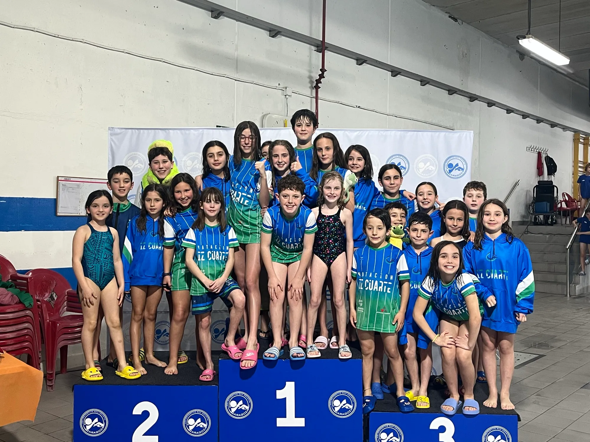 Equipo del club celebrando en el podio de una competición.