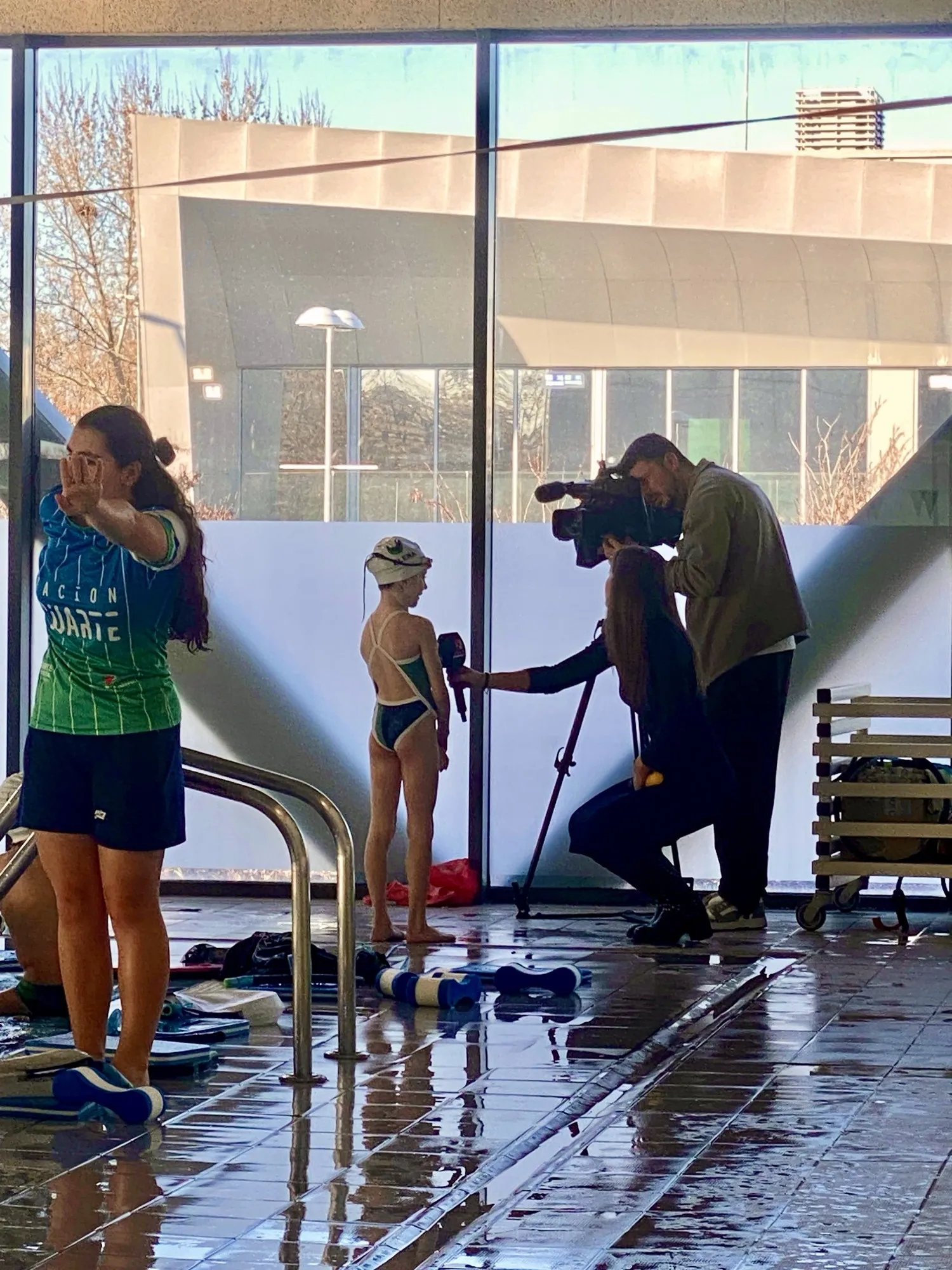 El equipo de Menuda Cantera entrevistando a una nadadora del club a pie de piscina